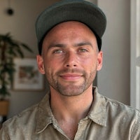 a bald man wearing a hat and shirt